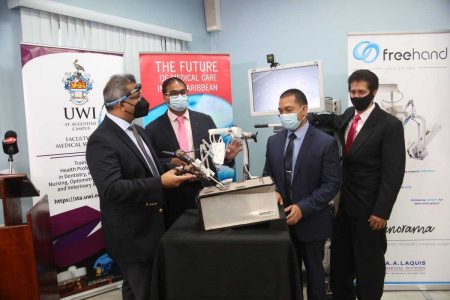 Dr Yardesh Singh,, left, The UWI Faculty of Medical Science Deputy Dean Prof Dilip Dan, UWI/NWRHA, Prof Shamir Cawich and AA Laquis Clinical Manager Dirk Cabral pose with the CoBOT during the announcement of a breakthrough Medical Technology that seeks to revolutionize the performance of surgeries in Trinidad & Tobago at the Doctor’s Lounge, Port-of-Spain, General Hospital.