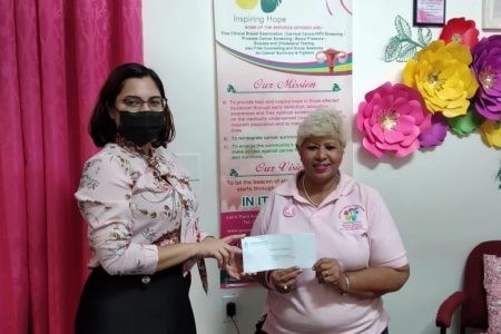 A representative of Demerara Bank (left) handing over the donation to a representative of the Guyana Cancer Foundation