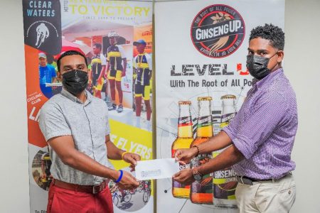 Seweon McGarrell (R), Head of Trade Marketing at Guyana Breweries Inc., makes the presentation to Linden Bauxite Flyers Cycling Club’s. 