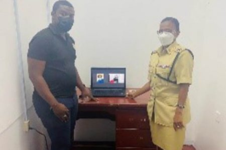 The handing over of the laptop from the Court to the Brickdam Police Station to assist following last Saturday’s fire. In photo Ghwan Lynch (left), from the IT department of the Supreme Court, hands over the device to Assistant Superintendent of Police Shellon Daniels. 