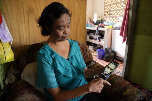 Carlawatie Ramlogan shows a picture of her son Kishoan Ramlogan, who was murdered in Arima on Tuesday.