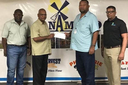 RHTYSC Secretary/CEO Hilbert Foster receives sponsorship from NAMLICO Managing Director Bert Sukhai in the presence of other management officials.
