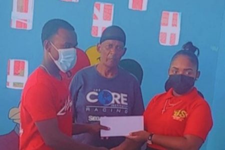 Balram Narine receives the sponsorship cheaque from Kesha Chesney, a representative from J&S Taxi Service in the presence of cycling coach, Randolph Roberts.