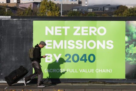A man walks past a advertising in relation with the UN Climate Change Conference (COP 26) where world leaders discuss how to tackle climate change on a global scale, near the conference area in Glasgow Scotland, Britain October 30, 2021. REUTERS/Yves Herman