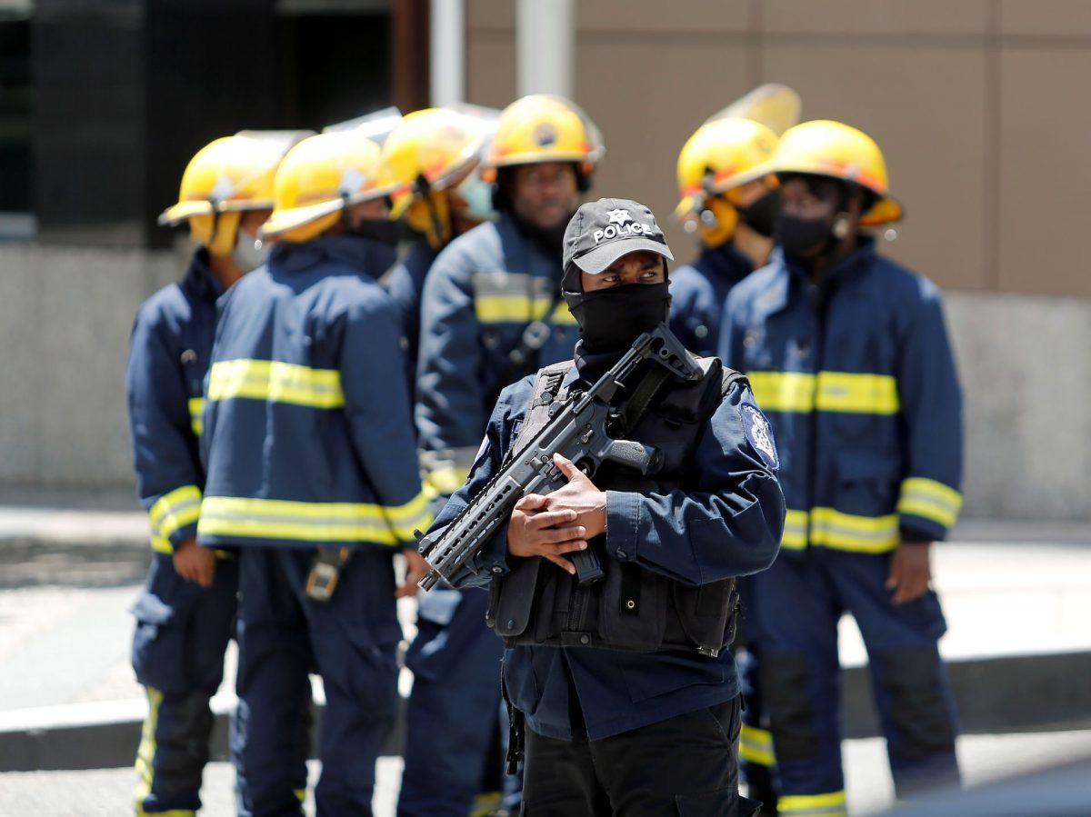 A police officer stands guard as a group of fire officers gather at the site of the Government Plaza Parkade, corner of Edward and Queen Janelle Commissiong Streets,, Port-of-Spain, following an explosion in the Parkade, yesterday.

ABRAHAM DIAZ