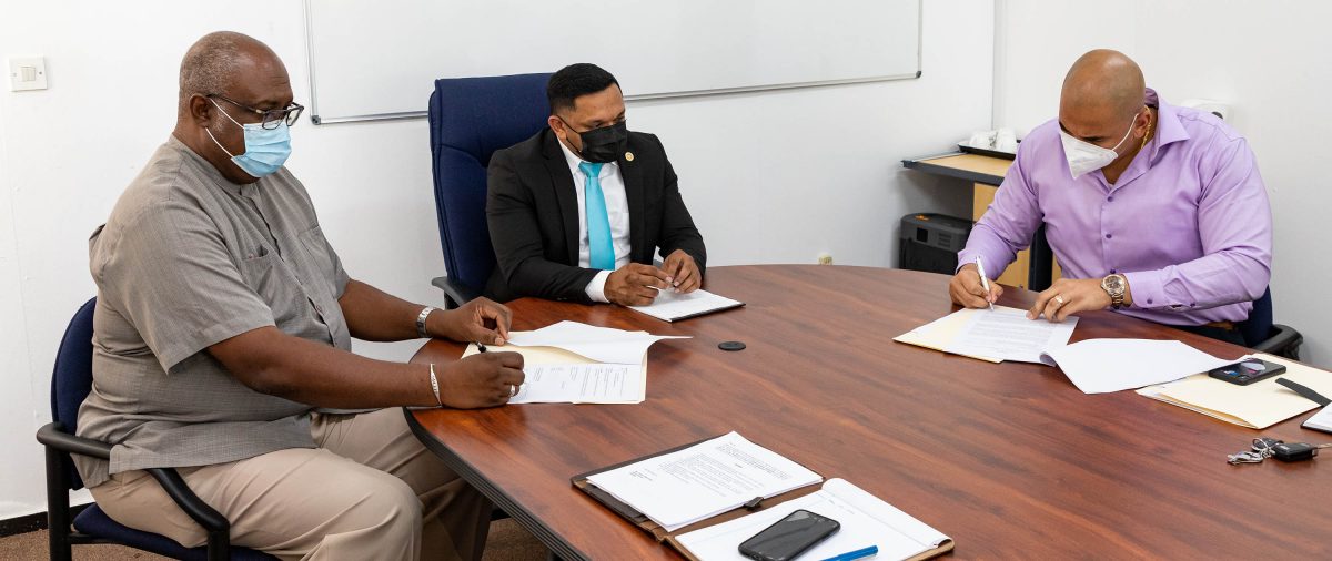 The GGDMA’s Andron Alphonso (right) and GGMC’s Newell Dennison (left) signing the agreement. Also in photo is Minister of Natural Resources, Vickram Bharrat