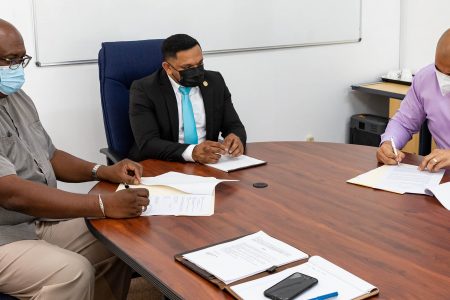 The GGDMA’s Andron Alphonso (right) and GGMC’s Newell Dennison (left) signing the agreement. Also in photo is Minister of Natural Resources, Vickram Bharrat