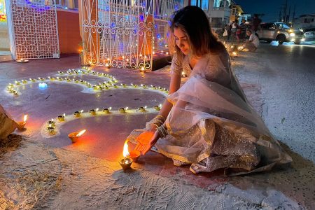 A young woman places a diya in front of the Alexander Village Vishnu Mandir in observance of Diwali. See more photos from Diwali night on centre pages. (Photo by David Papannah) 