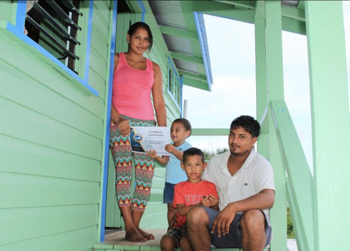 One of the beneficiary families with their certificate of ownership