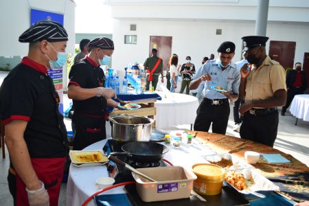 Serving members of the disciplined forces tasting the food at the engageMENt exhibition hosted at the Arthur Chung Conference Centre on Friday in observance of International Men’s Day 2021 (Orlando Charles photo)