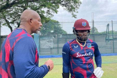 Head coach Phil Simmons (left) shares some tips with all-rounder, Kyle Mayers