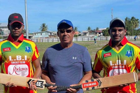 Hubern Evans (centre) poses with the two recipients of the bats, Ariel Tilku (left) and Aaron Beharry