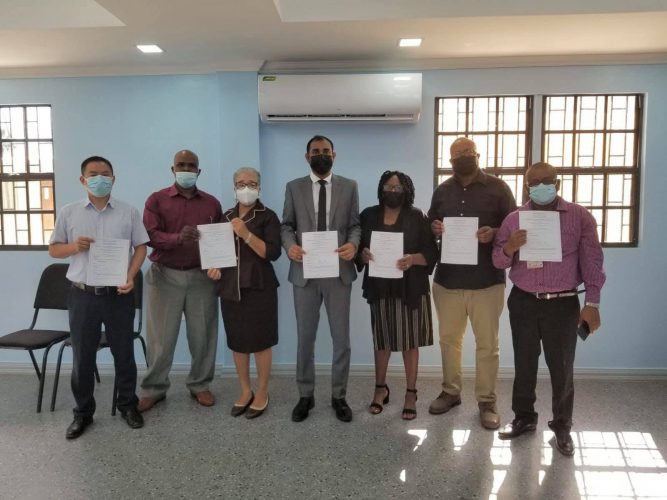 NACCIE representatives and members of BOSAI’s management along with Chief Labour Officer Dhaneshwar Deonarine (at centre) hold signed copies of the resolutions from the meeting.  (Ministry of Labour Photo)