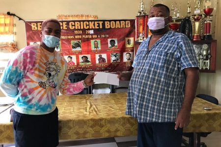 West Indies batsman Shimron Hetmyer (left) hands over contribution to RHTYSC Secretary Hilbert Foster.