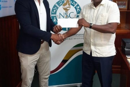 GTTA president, Godfrey Munroe (left) receives from Director of Sport, Steve Ninvalle, support from the National Sports Commission for the upcoming Pan American TT championships in Lima, Peru, November 13-19.