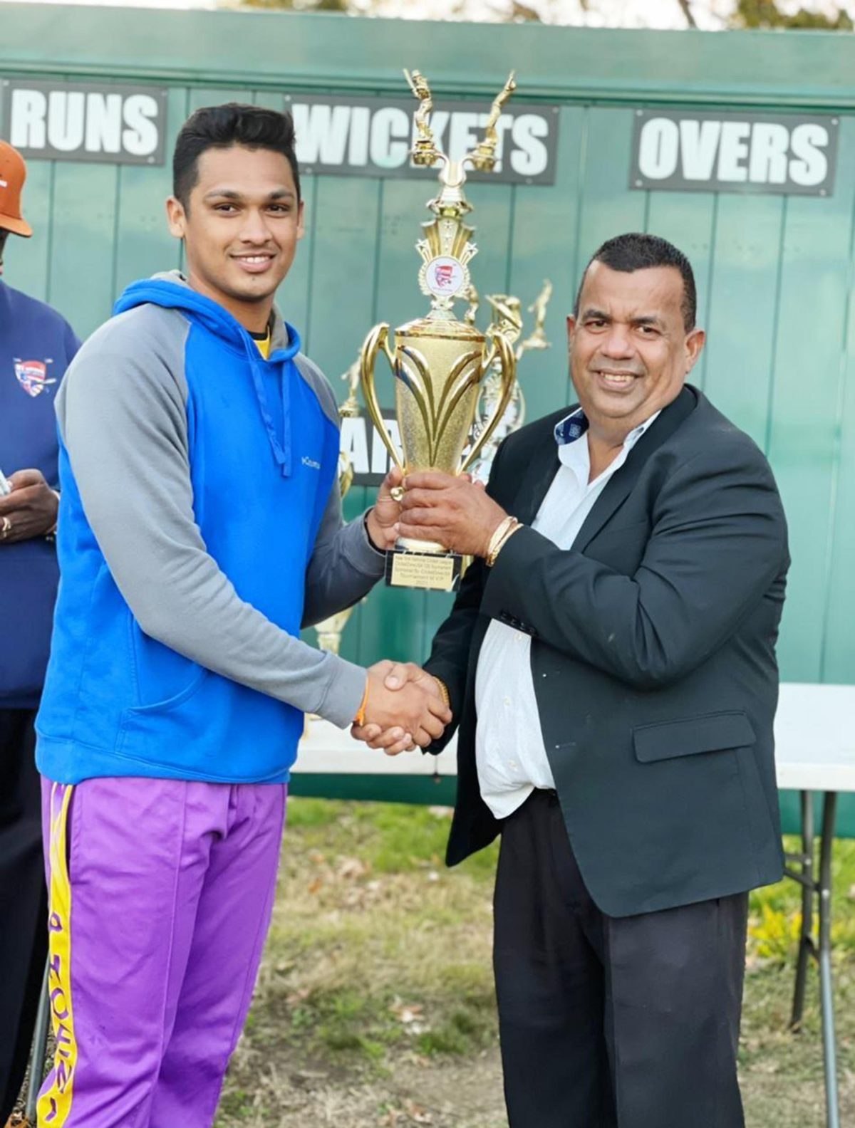 Akshaya Persaud (left) receives his accolade from businessman, Hafeez Ali.
