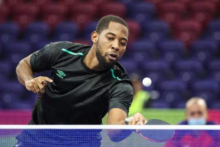 Guyana’s Shemar Britton plays a forehand return.