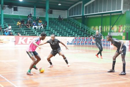 Blocked!  Jehu Regis (pink) of Silver Bullets in the process of being challenged by the Leopold Street duo of Okeene Fraser (2nd from left) and Daren Benjamin (right) in the GFF/Kashif and Shanghai Organization Futsal Championship at the Cliff Anderson Sports Hall on Homestretch Avenue 