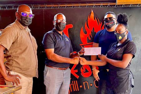 GFF Boss Wayne Forde (2nd left) collects the sponsorship from Shania David in the presence of (from left) Aubrey ‘Shanghai’ Major and Managing Director Simeon Francis