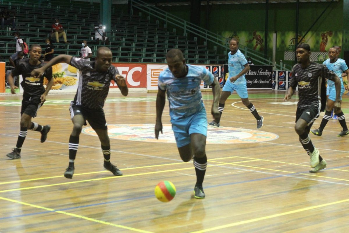 Selwyn Williams (right) of Back Circle on the attack against Timehri in the GFF/Kashif and Shanghai Organization Futsal Championship at the Cliff Anderson Sports Hall