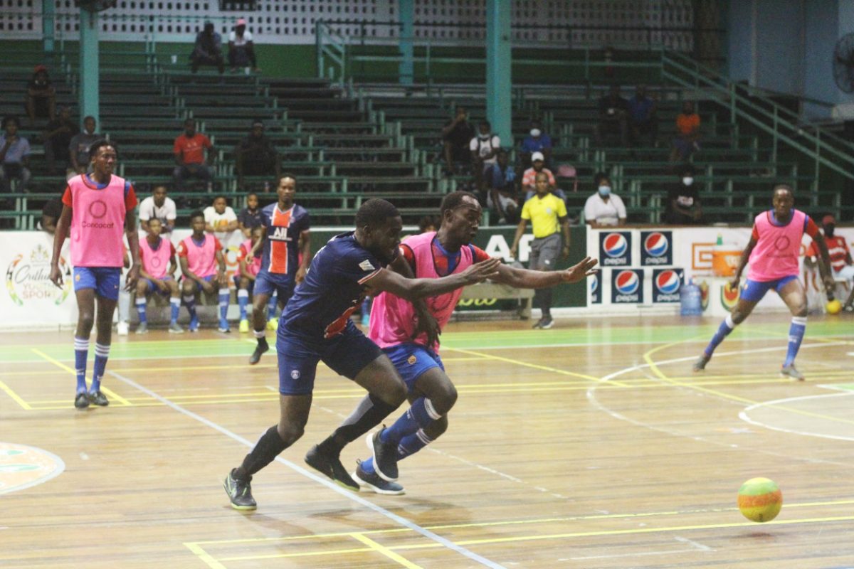 Jeremy Garrett of Sparta Boss (left) tussling with David George of California Square for possession of the ball during their clash in the Guyana Football Federation (GFF)/Kashif and Shanghai Organization Futsal Championship at the Cliff Anderson Sports Hall on Homestretch Avenue