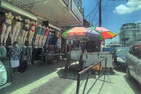 Some of vendors had placed carts and tables with their wares along the pavement outside of the Shamdas Kirpalani building on Regent Street, Georgetown