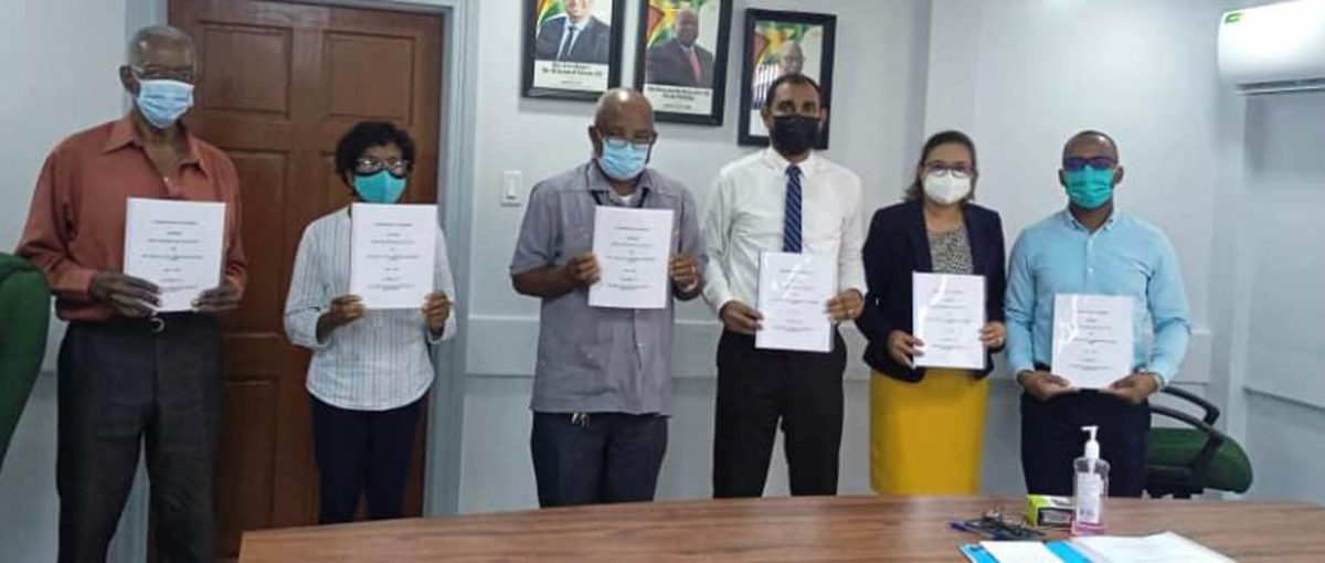Copies of the agreement being held up (Ministry of Labour photo)
