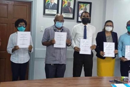 Copies of the agreement being held up (Ministry of Labour photo)

