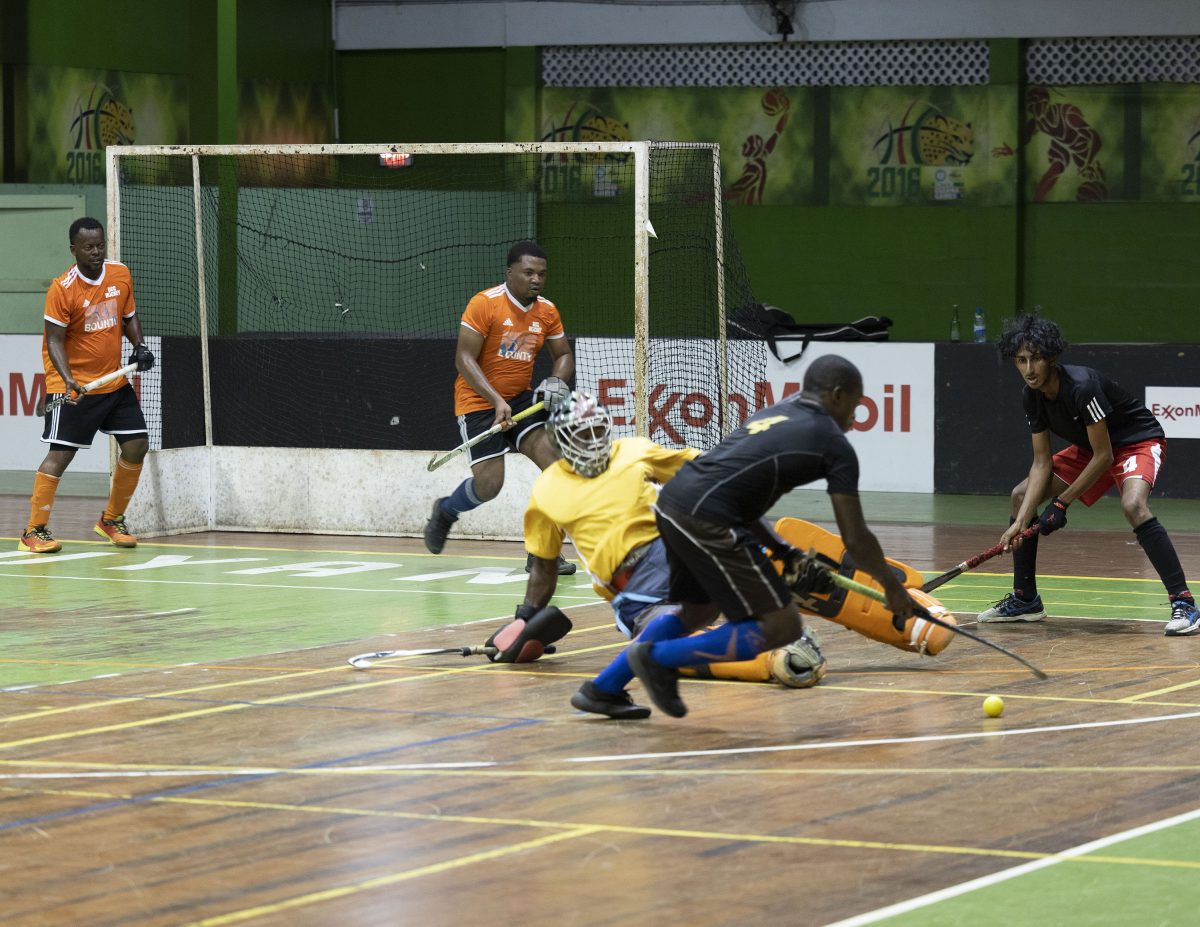 YMCA Old Fort’s Jael Gaskin attempts to evade the challenge of GCC goalkeeper Medroy Scotland during their men’s first-division clash at the Cliff Anderson Sports Hall in the ExxonMobil National Indoor Championship.