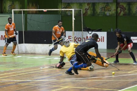 YMCA Old Fort’s Jael Gaskin attempts to evade the challenge of GCC goalkeeper Medroy Scotland during their men’s first-division clash at the Cliff Anderson Sports Hall in the ExxonMobil National Indoor Championship.
