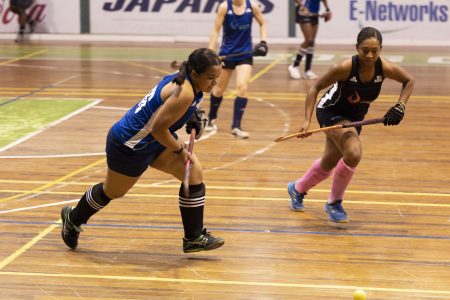 GCC Roulette’s Kirsten Gomes (blue) trying to evade the pursuit of GCC Ignite captain Aliyah Gordon at the Cliff Anderson Sports Hall in the ExxonMobil National Indoor Championship