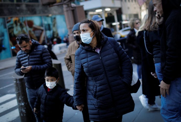 A women and a child wear protective face masks as they walk along 5th Avenue as new New York State indoor masking mandates went into effect amid the spread of the coronavirus disease (COVID-19) in New York City, New York, U.S., December 13, 2021. REUTERS/Mike Segar