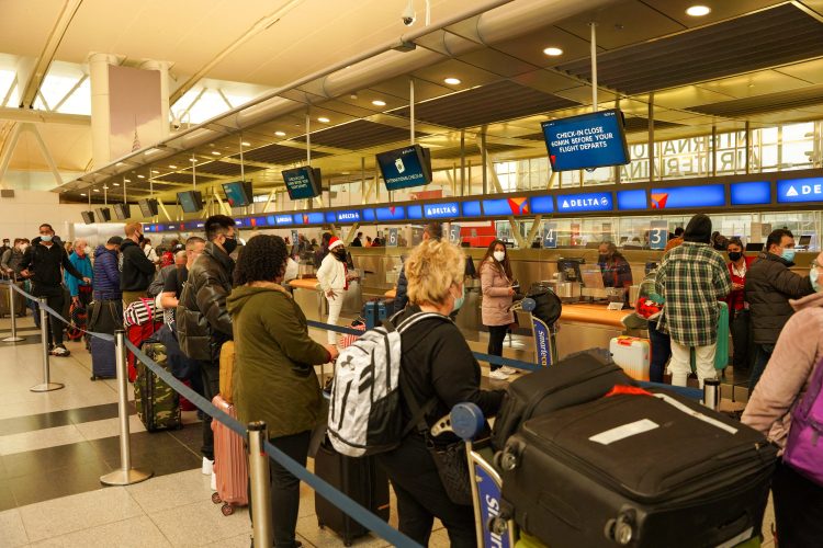 Passengers line up at John F. Kennedy International Airport after airlines announced numerous flights were canceled during the spread of the Omicron coronavirus variant on Christmas Eve in Queens, New York City, U.S., December 24, 2021. REUTERS/Dieu-Nalio Chery