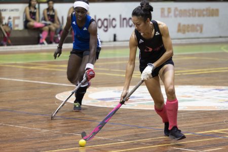 Samantha Fernandes of GCC Spartans on the attack while being pursued by Shebiki Baptiste of GCC Roulettes in the ExxonMobil National Indoor Hockey Championship at the Cliff Anderson Sports Hall, Homestretch Avenue.
