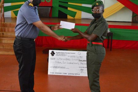 Commander Sean Harmon (left) presents Private Shiquanna Blair of DHQ/IG Secretariat with her cash incentive. (GDF photo)
