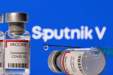 FILE PHOTO: Vials labelled "VACCINE Coronavirus COVID-19" and a syringe are seen in front of a displayed Sputnik V logo in this illustration taken December 11, 2021. REUTERS/Dado Ruvic