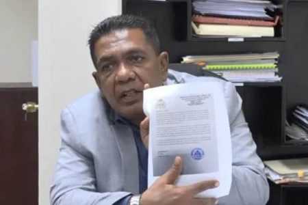 Minister of Agricultural Zulfikar Mustapha displays a letter that was sent to Panamanian authorities last year demanding outstanding payment (Department of Public Information photo)