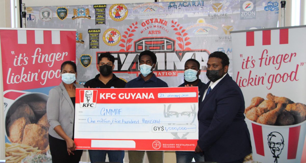 GMMAF Vice-President Sherwin Sandy (right) receives the sponsorship cheque from Marketing Officer of Beharry Restaurant Holdings Pamela Manasseh (left) in the presence of several athletes.