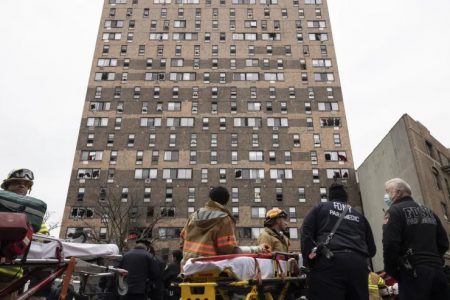 Emergency personnel work at the scene of a fatal fire at an apartment building in the Bronx on Sunday, Jan. 9, 2022, in New York. The majority of victims were suffering from severe smoke inhalation, FDNY Commissioner Daniel Nigro said. (AP Photo/Yuki Iwamura)