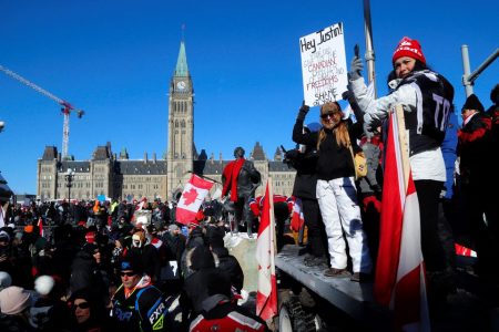 Protestors stand in front of the Parliament Buildings as truckers take part in a convoy to protest coronavirus disease (COVID-19) vaccine mandates for cross-border truck drivers in Ottawa, Ontario, Canada, January 29, 2022. REUTERS/Patrick Doyle