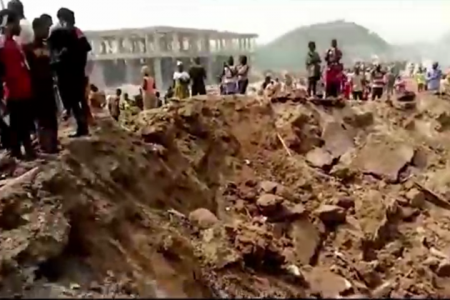 This screenshot taken from a video posted on social media shows a massive crater in the ground following an explosion in Ghana's rural Western Region, Ghana, on Jan. 20, 2022. (Joseph Kabenlah Amihere via Reuters)