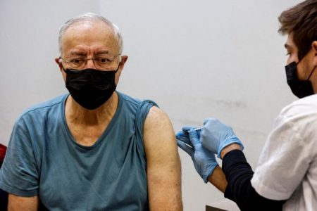 A man receives the fourth dose of the coronavirus disease (COVID-19) vaccine after Israel approved a second booster shot for the immunocompromised, people over 60 years and medical staff, in Tel Aviv, Israel January 3, 2022. REUTERS/Amir Cohen