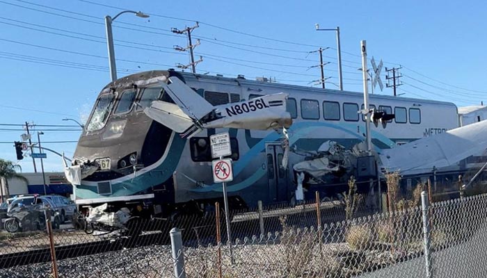 A train hits an aircraft that crashed on railway tracks in Los Angeles, California, U.S. January 9, 2022 in this screen grab from a social media video obtained by Reuters.