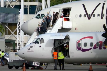 Passengers disembark the Virgin Atlantic Airlines aircraft after it landed at the ANR Robinson International Airport on Saturday.