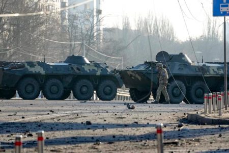 A soldier walks along Ukrainian armoured vehicles blocking a street in Kyiv, Ukraine, 26 Feb, 2022. (AP)