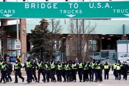 Canadian police deploy on February 12, 2022, to move protesters blocking access to the Ambassador Bridge demanding an end to government COVID-19 mandates, in Windsor, Ontario, Canada. (AFP)