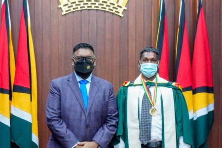 Davendra Kissoon (right), the University of Guyana’s 2020/2021 Valedictorian after receiving the President’s Medal for the Best Graduating Bachelor’s Degree Student, from President Irfaan Ali on Monday.