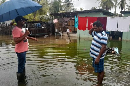 Region Five’s Chairman Vickchand Ramphal (left) interacting with a flood-affected resident 