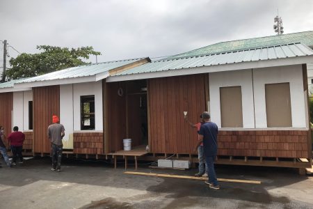 Manufacturers showcasing ‘taste of Guyana’ at Umana Yana duty-free shop: An eco-friendly timber home, manufactured by DuraVilla Homes, being built in the compound of the Umana Yana, where local manufacturers are currently showcasing their products. (Lazeena Yearwood photo) 