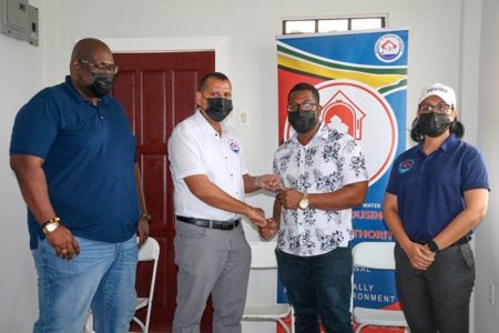 Travis Bowman (second from right) receiving the keys to his home from Minister of Housing and Water, Collin Croal and Minister within the Ministry, Susan Rodrigues (right) and Chief Executive Officer (CEO) of the CHPA, Sherwyn Greaves.